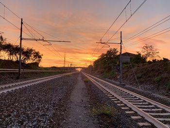 Railroad tracks against sky during sunset