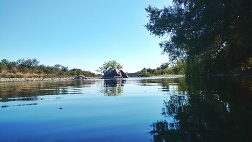 Scenic view of lake against clear blue sky