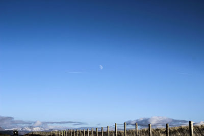 Scenic view of vapor trails against clear blue sky