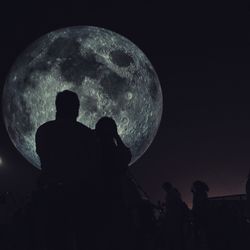 Silhouette man against moon in sky at night