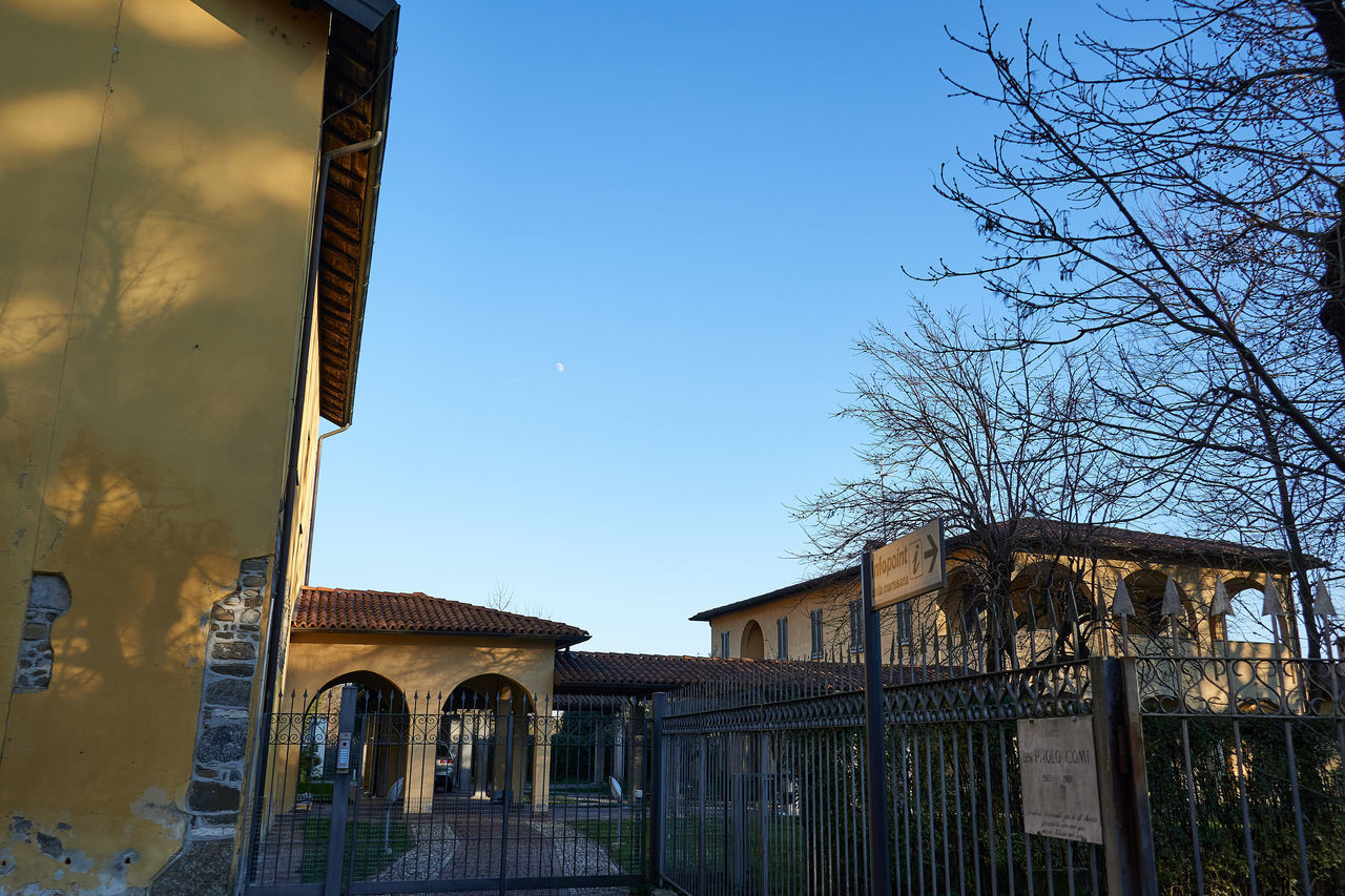 LOW ANGLE VIEW OF BUILDING AND TREES AGAINST SKY