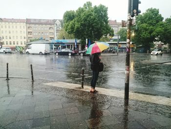 Woman standing by railing in city