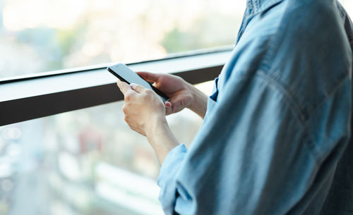 Midsection of man using mobile phone