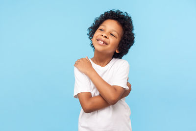 Happy girl standing against blue background