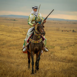 Man riding horse on field