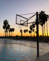 Silhouette of basketball hoop against sky during sunset