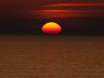 Scenic view of sea against orange sky