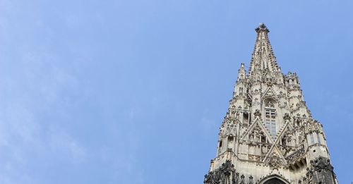 Low angle view of clock tower against blue sky