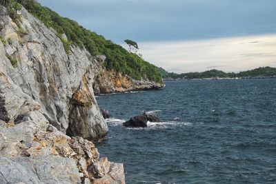 View of rock formation in sea against sky