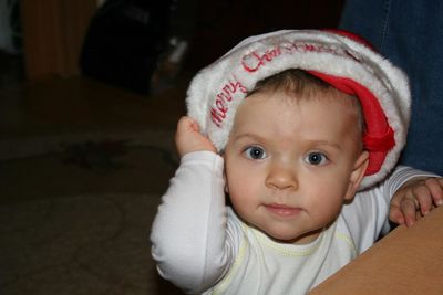 Portrait of baby girl wearing santa hat at home