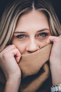 Portrait of young woman covering face with hand