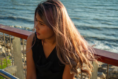 Portrait of young woman looking at sea