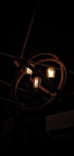 Low angle view of illuminated lamp at night