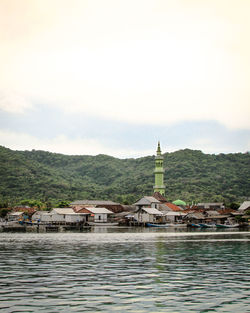 Houses by building against sky