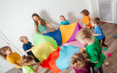 High angle view of people standing on multi colored umbrellas