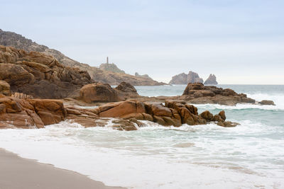 Rocks on beach against sky