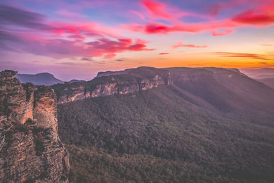 Scenic view of mountain against cloudy sky during sunset