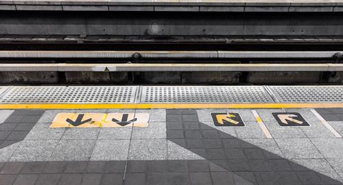 High angle view of yellow text on railroad station platform