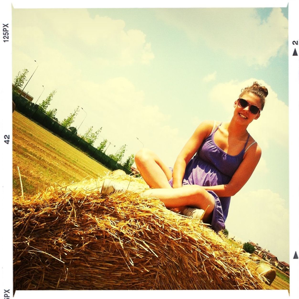 transfer print, lifestyles, leisure activity, auto post production filter, sky, young adult, young women, sitting, holding, person, full length, casual clothing, field, waist up, plant, three quarter length, outdoors