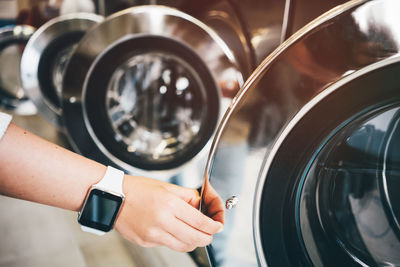 Close-up of woman hand opening washing machine