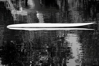 Reflection of boat floating on lake