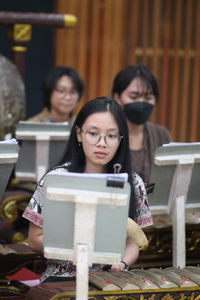 Low angle view of young woman standing against blurred background