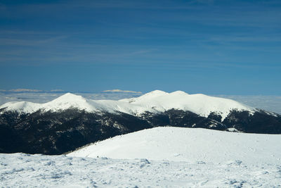 Scenic view of snow covered mountains against sky