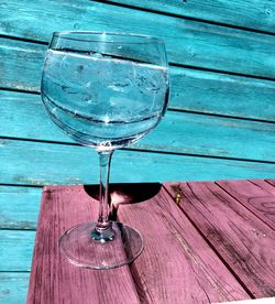 Close-up of a wine glass against wooden wall