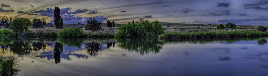 Scenic view of calm lake against cloudy sky