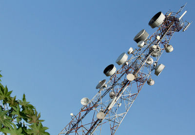 Low angle view of communications tower against clear blue sky