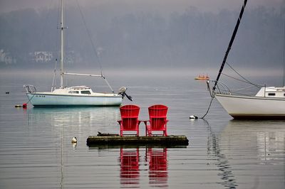 Frontal view of two wooden chairs on water platform