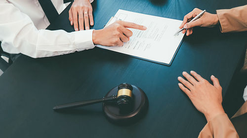 Low section of people holding hands on table