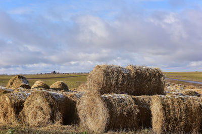 Hay bales on field against sky