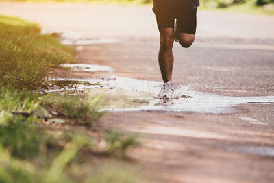 Low section of man running on footpath