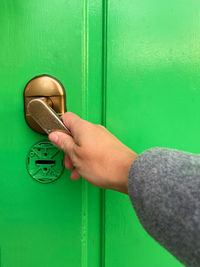 Hand opening a green door