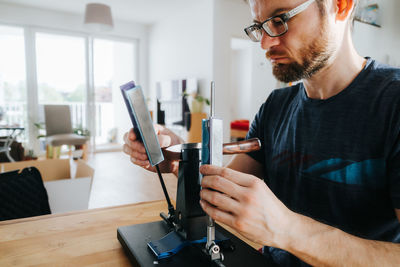 Man sharpening knife with whetstone decice