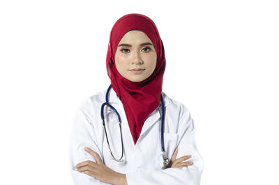 Portrait of young woman standing against white background