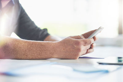 Midsection of businessman using mobile phone