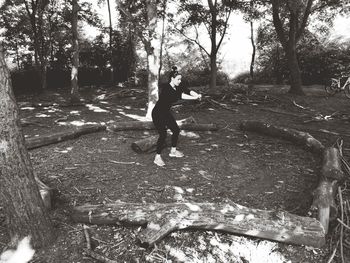 Full length of man standing on field against trees in forest