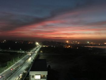 High angle view of illuminated city against sky at sunset