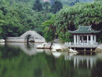 Gazebo reflection in lake against trees