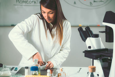 Young scientist preparing herbal medicine at laboratory