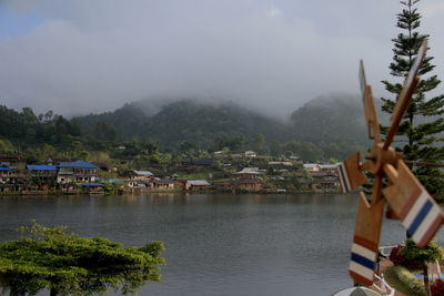 Scenic view of river by buildings against sky