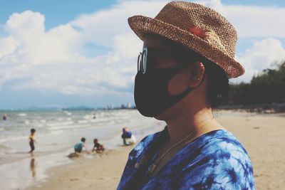Close-up of woman wearing mask standing on beach