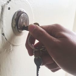 Cropped hand holding key in door