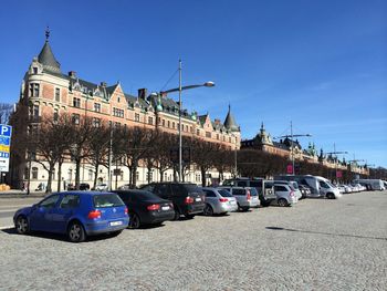 Cars parked by bare trees in front of church