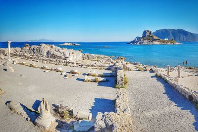 Scenic view of beach against clear blue sky