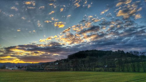 Scenic view of field against sky at sunset