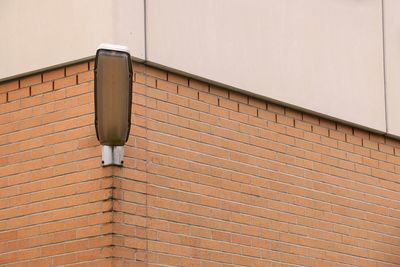 Close-up of street lamp on wall against building