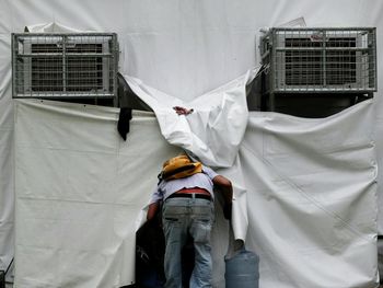 Rear view of man entering in building covered with plastics at construction site